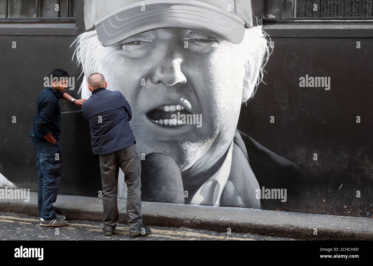 Les membres du public regarder une peinture murale du président américain Donald Trump dans le centre-ville de Dublin par l'artiste sous-ensemble. Banque D'Images