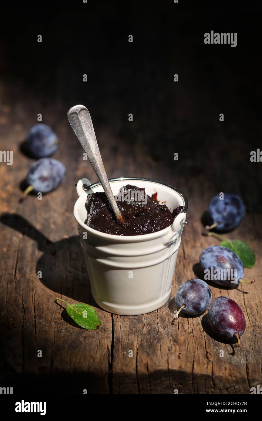 Seau de confiture épaisse de prune sur table en bois Banque D'Images