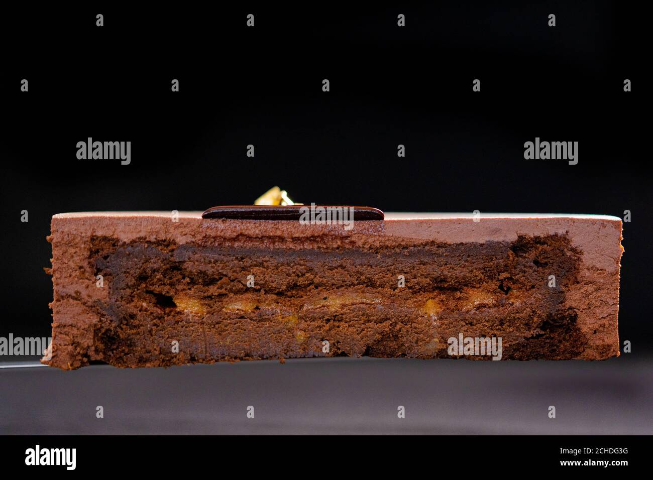 Moitié ou tranche de gâteau de mousse au chocolat isolé sur fond noir. Copier l'espace. Photo de haute qualité. Banque D'Images