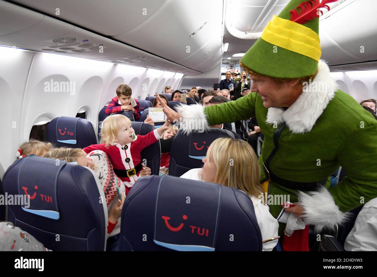 USAGE ÉDITORIAL SEULEMENT Wallace Walkden, âgé de 18 mois, à bord du vol TUI  Airways TOM2144 de Manchester à Laponie, Reçoit le cadeau de Noël ultime  d'un usurpateur Buddy l'Elf sous la