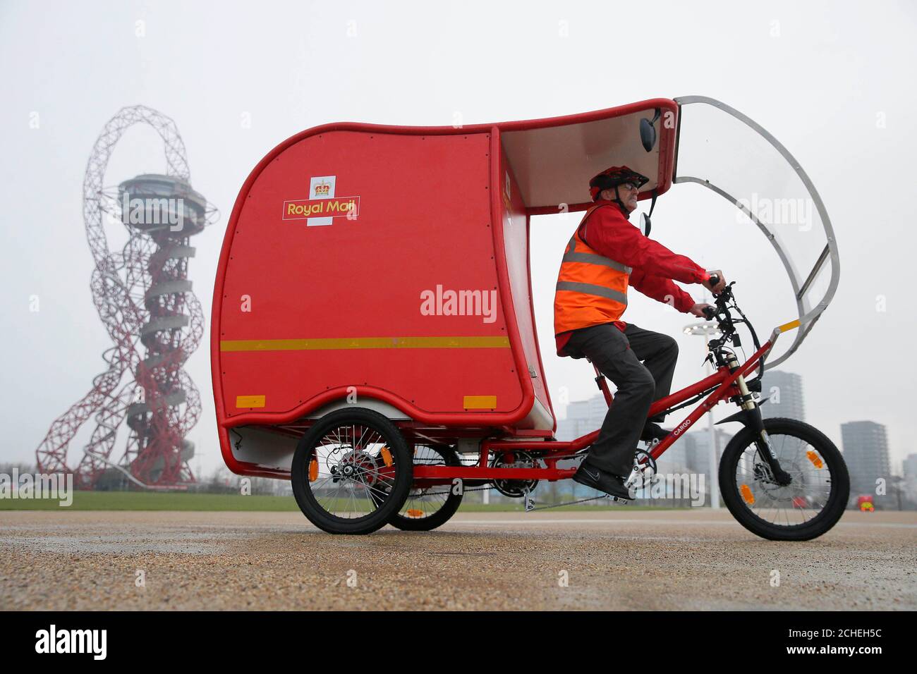 Utilisez uniquement rédactionnel Postman Nigel Roughty devant l'ArcelorMittal Orbit à l'occasion du dévoilement de l'émission zéro carbone e-Trikes, qui sont essentiellement alimenté par une combinaison de l'énergie solaire, batterie et technologie de freinage, et sera à l'essai par Royal Mail à Stratford dans l'Est de Londres, Cambridge et Sutton court à la fin du mois. Banque D'Images