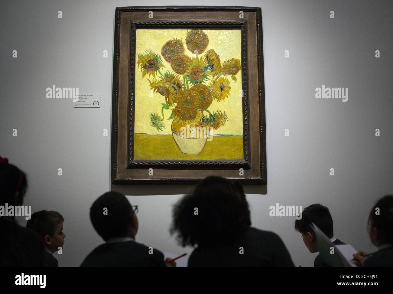 Les enfants de l'école examiner 'Sunflowers" (1888) de Vincent van Gogh au cours de la prévisualisation pour l'EY : exposition Van Gogh et la Grande-Bretagne à la Tate Britain, Londres, qui jette un regard nouveau sur l'artiste à travers sa relation avec la Grande-Bretagne. Banque D'Images