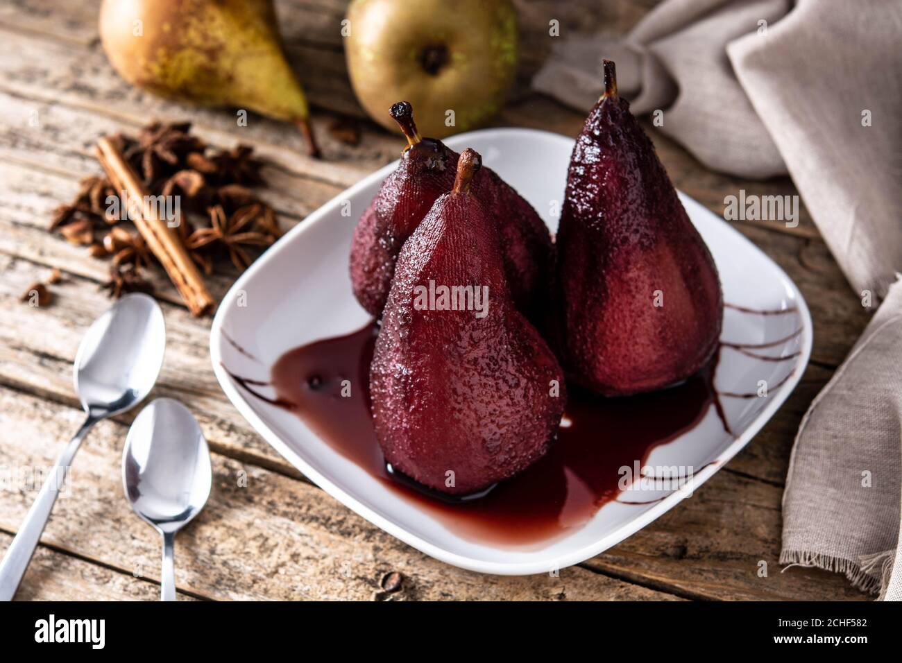 Poires pochées au vin rouge sur une table en bois Banque D'Images