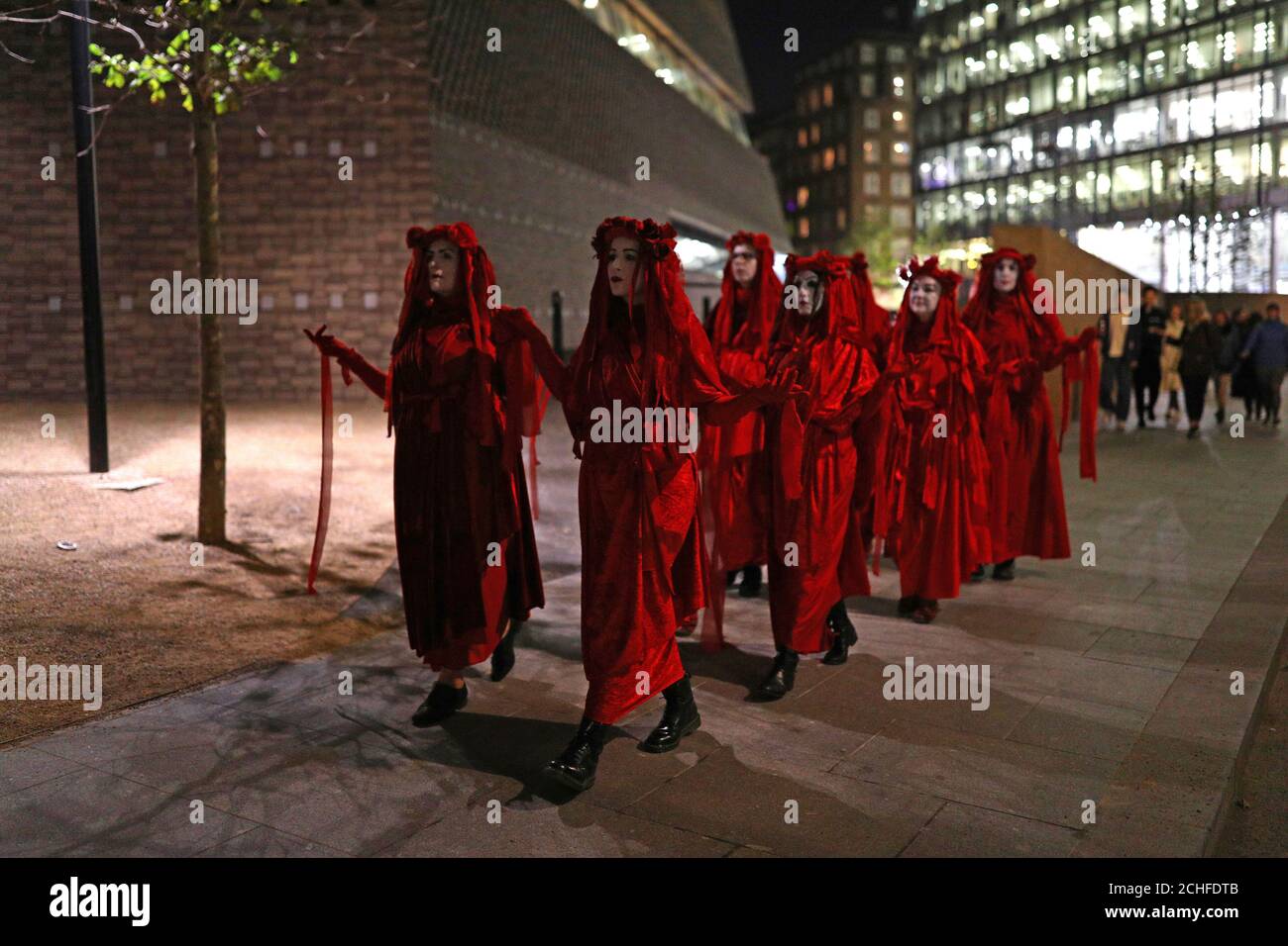 Les militants de la rébellion de l'extinction se promondent autour du Tate Modern, tandis que d'autres projettent des messages sur le bâtiment de Londres. Le groupe a annoncé cette semaine qu'il allait descendre dans les rues dans les 15 prochaines nuits, en prévoyant de fermer les routes autour de Westminster et d'organiser un sit-in à l'aéroport de City à Londres dans le cadre de leurs manifestations. Banque D'Images