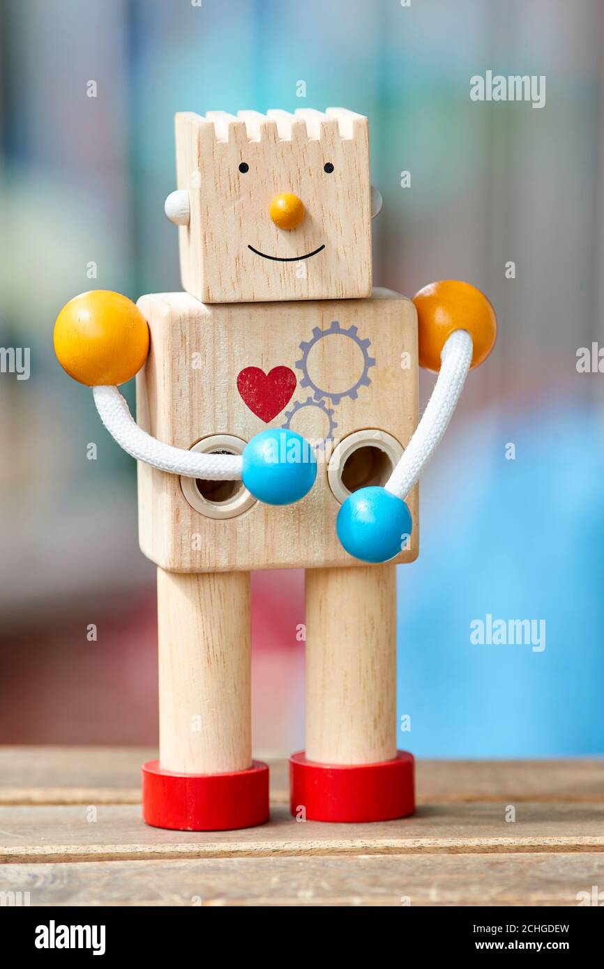 Robot jouet en bois avec coeur rouge et sourire. Arrière-plan flou Photo  Stock - Alamy