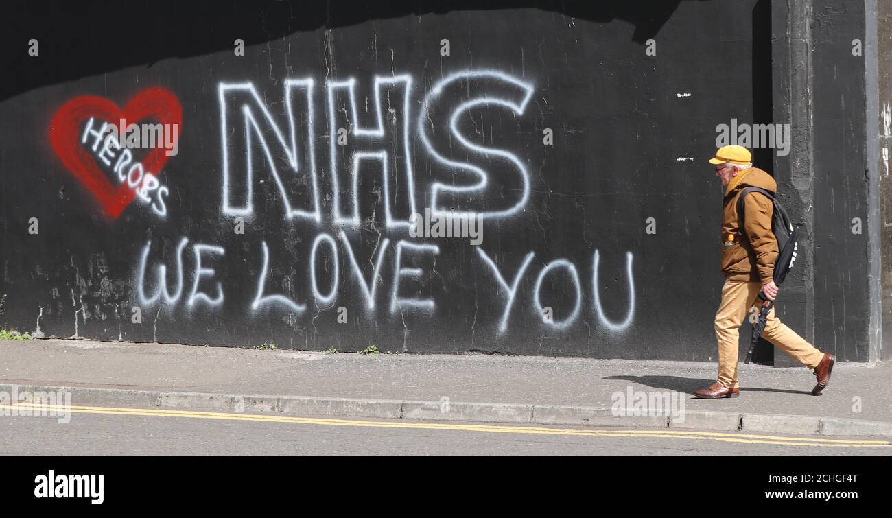 Un homme passe devant les graffitis pour soutenir le personnel du NHS qui lutte contre l'épidémie de coronavirus, dans le quartier loyaliste de Sandy Row à Belfast. Banque D'Images