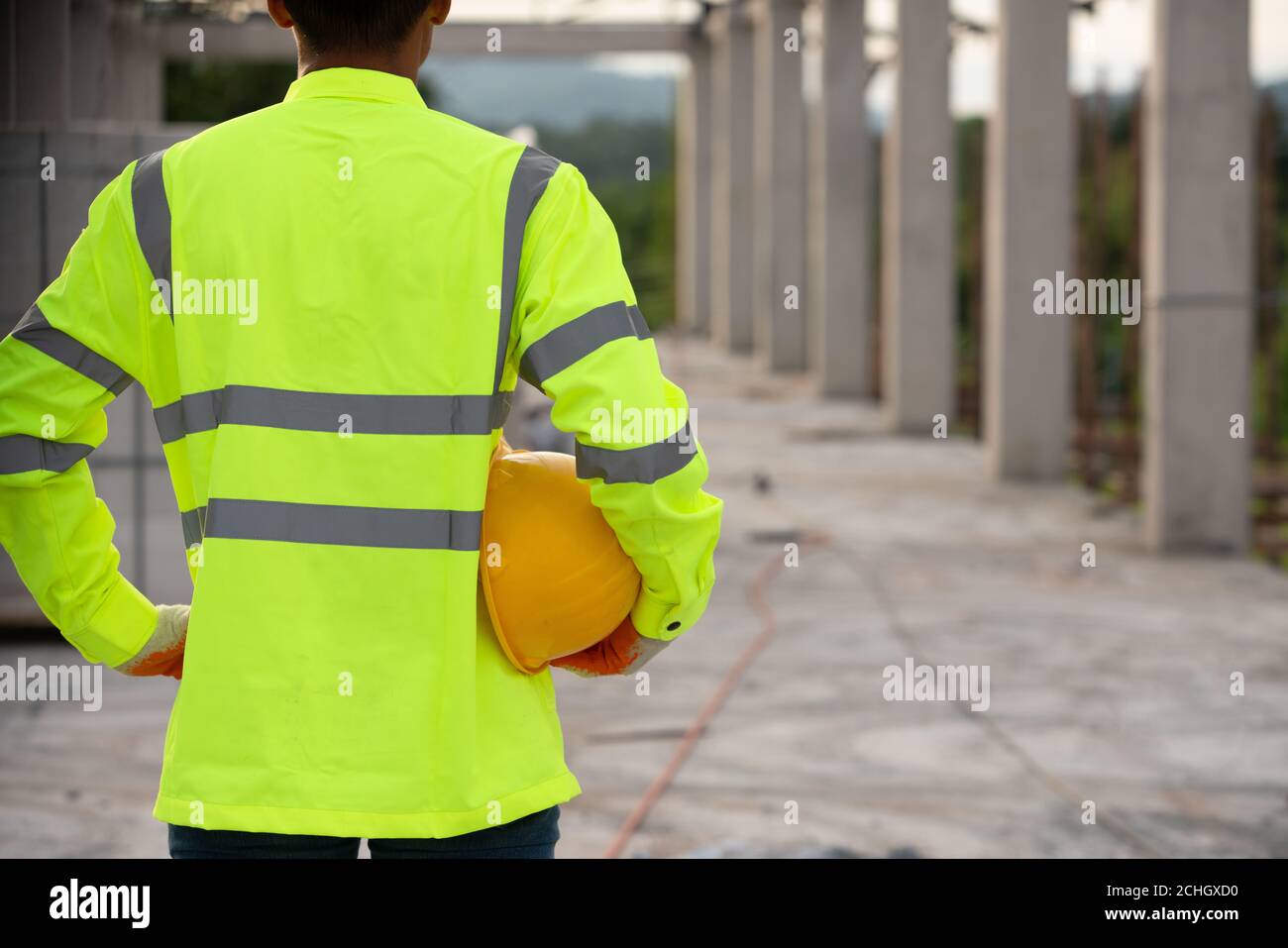 Un travailleur dans l'uniforme tenant un casque pour la sécurité dans le chantier de construction Banque D'Images