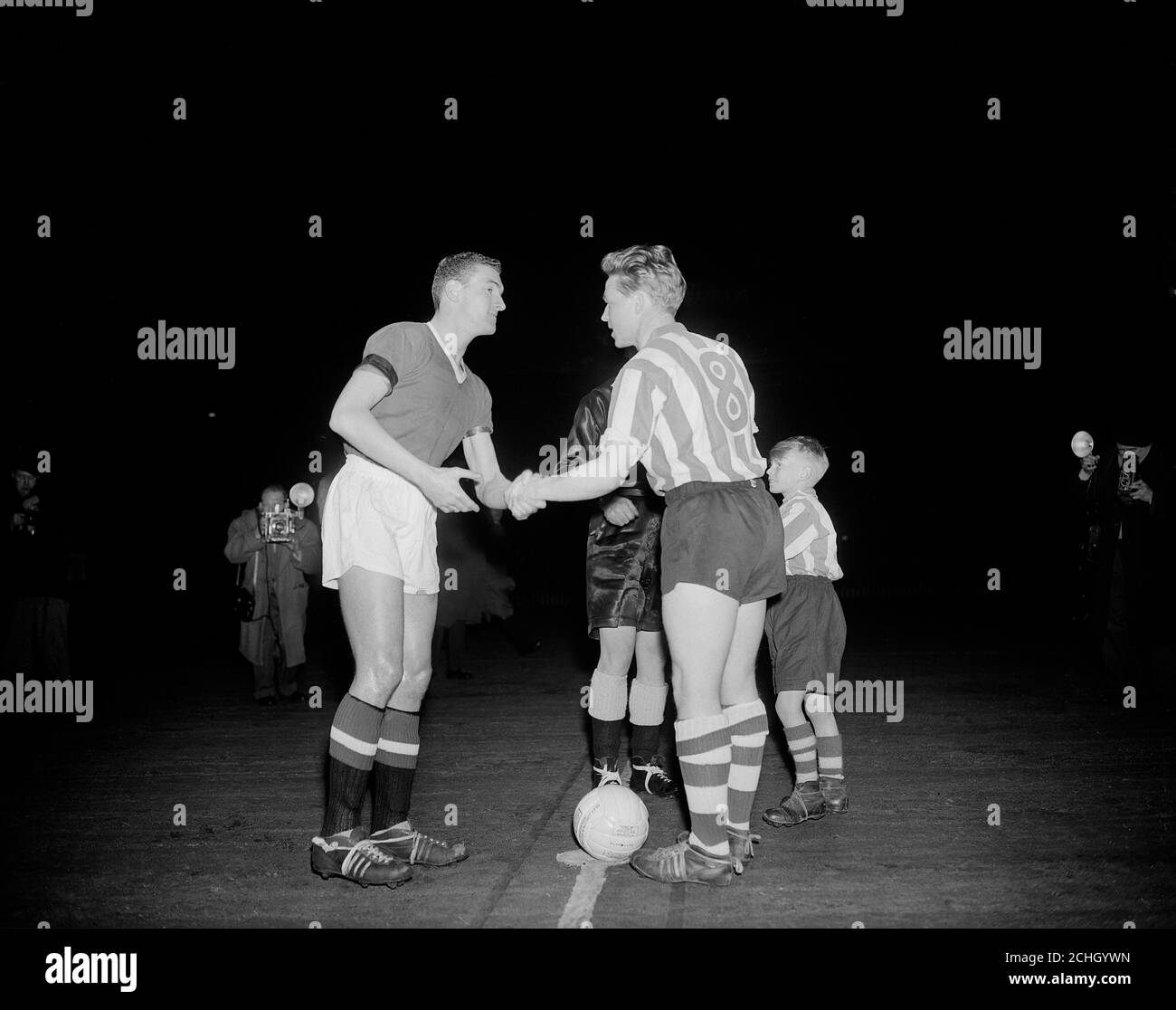 Les deux capitaines, Bill Foulkes (l) de Manchester United et Albert Quixall (r) de Sheffield Wednesday, se secouent la main avant le match. Première de United depuis la catastrophe aérienne de Munich. Banque D'Images