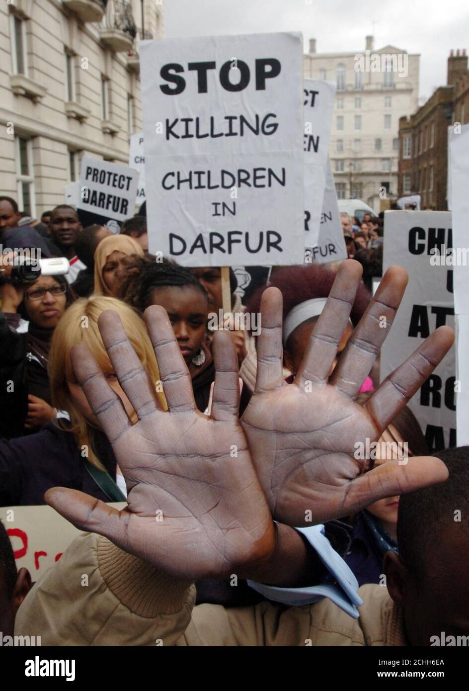 Les manifestants lèvent leurs mains peintes alors qu’ils se rassemblent devant l’ambassade du Soudan à Londres pour un rassemblement appelant à la fin de la crise au Darfour. Banque D'Images