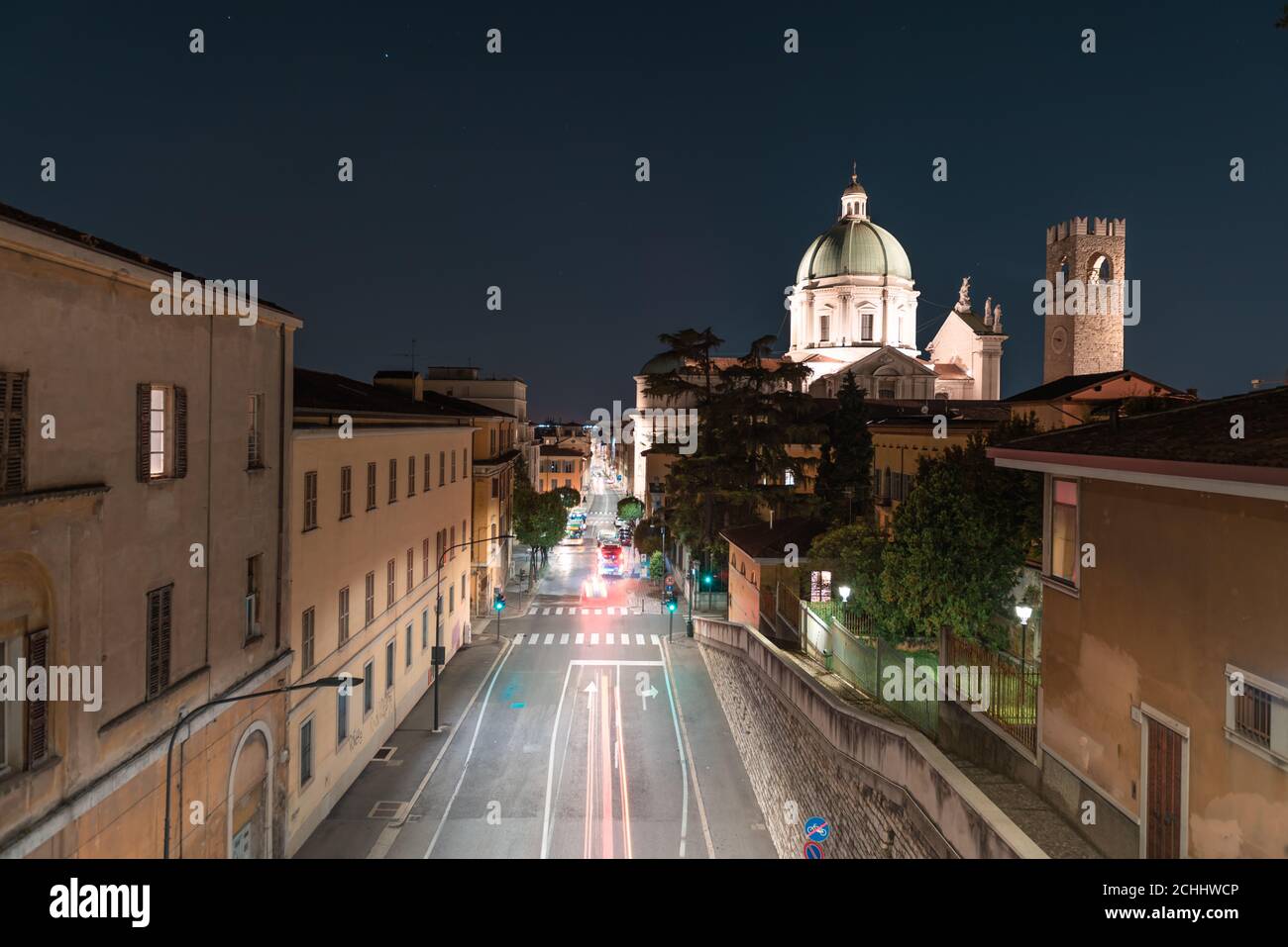 Zoom temporisé. Vue de nuit, du dôme du Duomo Nuovo avec mouvement de la ville, église catholique romaine et tour du Palazzo del Broletto, histoi Banque D'Images