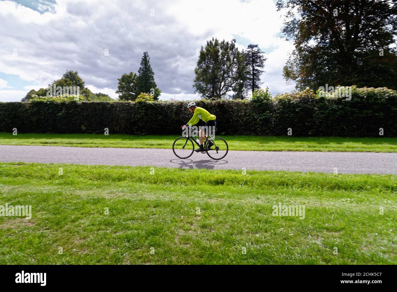 Cycliste d'âge moyen sur une route de campagne Dans les collines de Surrey, près de Dorking Surrey, Angleterre, Royaume-Uni Banque D'Images