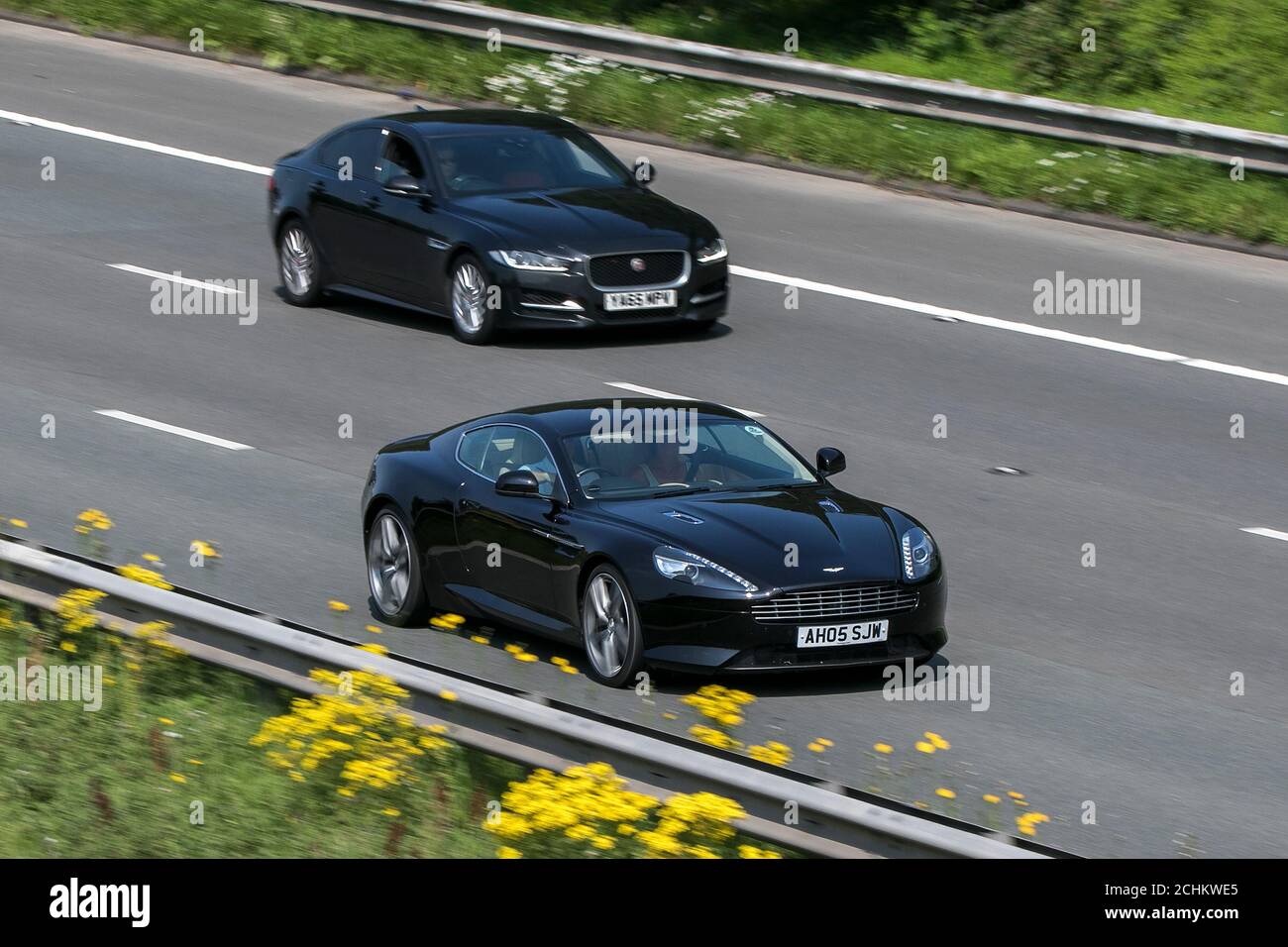 A 2012 Aston Martin Virage V12 Auto Black car coupé essence 499 BHP conduite sur l'autoroute M6 près de Preston dans Lancashire, Royaume-Uni. Banque D'Images