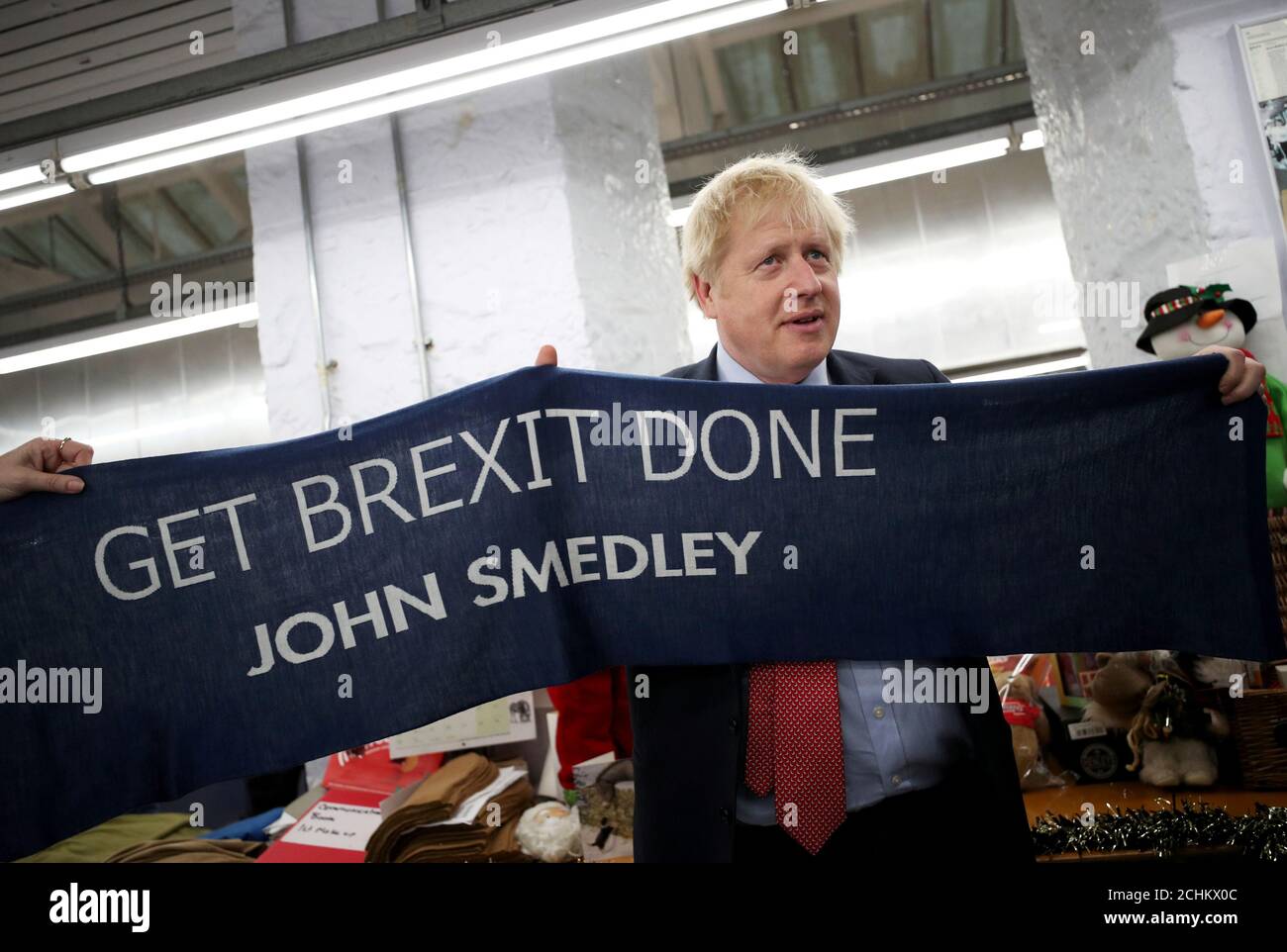 Le Premier ministre britannique Boris Johnson tient une écharpe avec le  slogan « Get Brexit done » alors qu'il visite John Smedley Mill à Matlock,  Derbyshire, Grande-Bretagne le 5 décembre 2019. REUTERS/Hannah