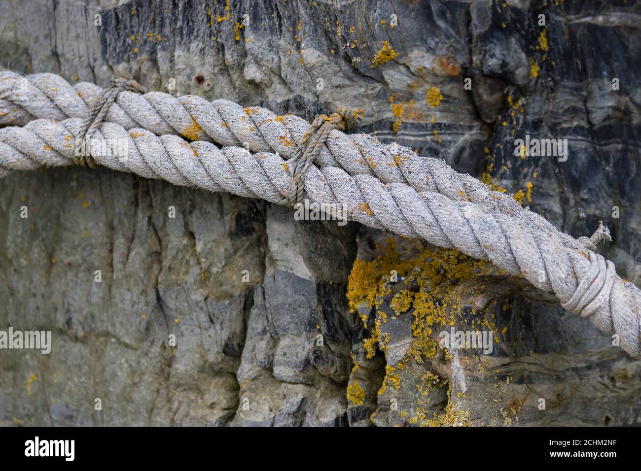 Une corde blanche épaisse attachée à une pierre Banque D'Images