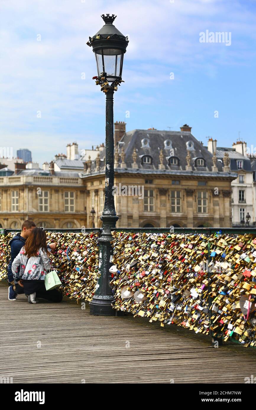 Amoureux et cadenas à Paris. Deux amoureux enverrouillent leur cadenas sur le pont des Arts Banque D'Images