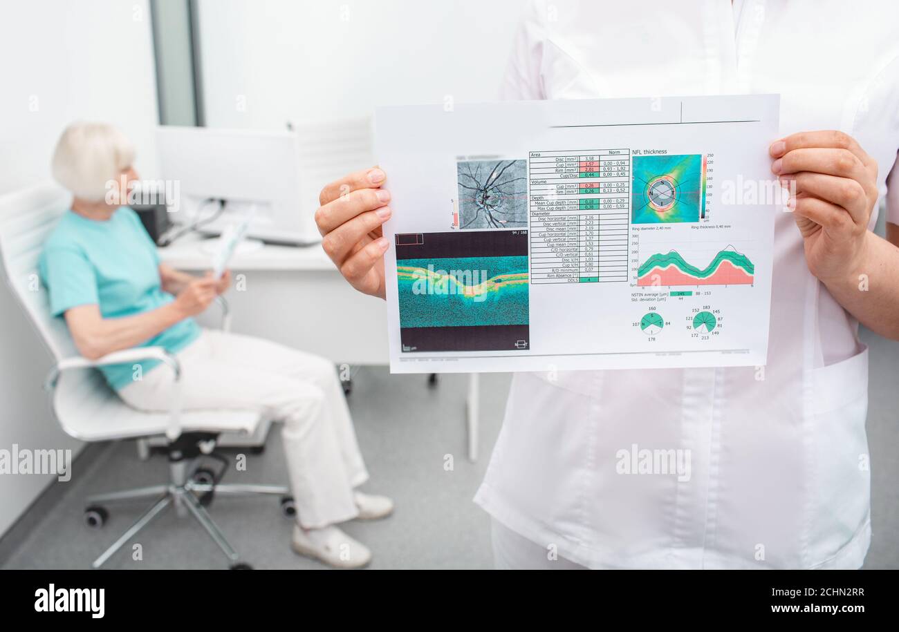 Ophtalmologiste chargé des analyses des tests de vision du patient, se concentre sur le premier plan. Femme âgée assise sur fond Banque D'Images