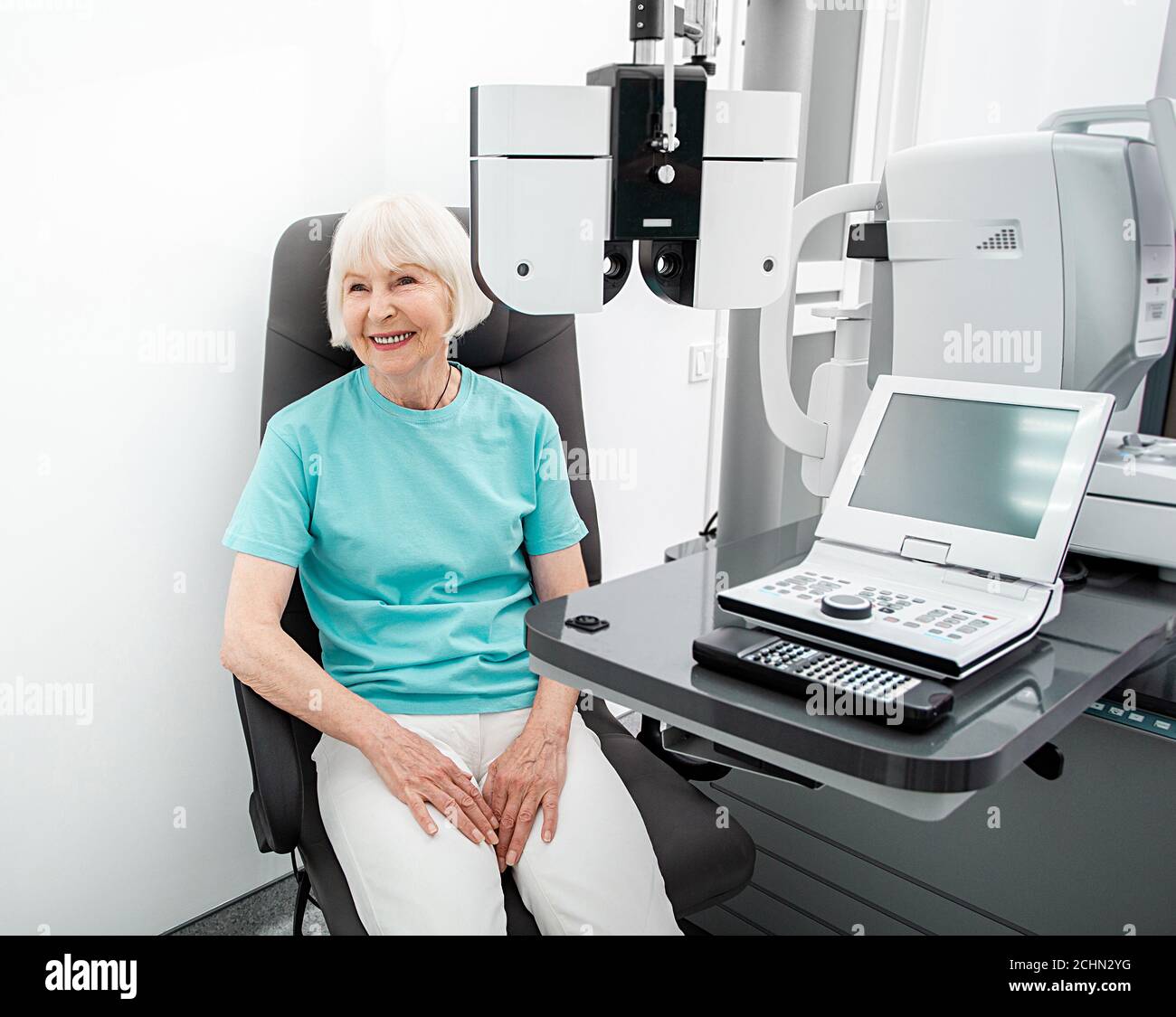 Femme âgée pendant un examen oculaire au bureau d'ophtalmologie. La vision de la femme contrôle avec un phoropter Banque D'Images