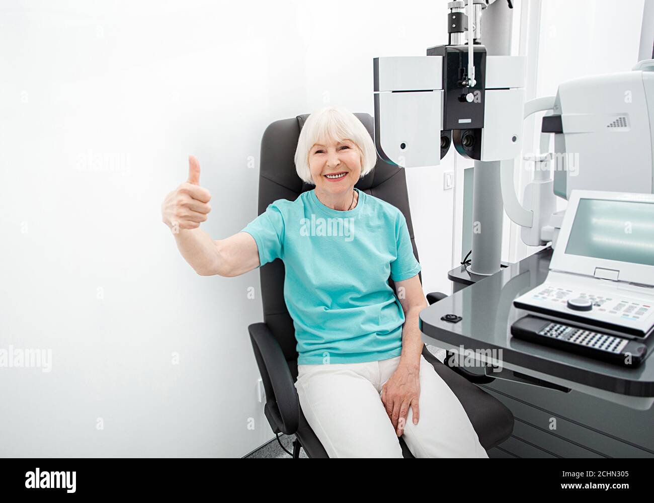 Une femme âgée se présente à un ophtalmologiste. La vision de la femme contrôle avec un phoropter Banque D'Images