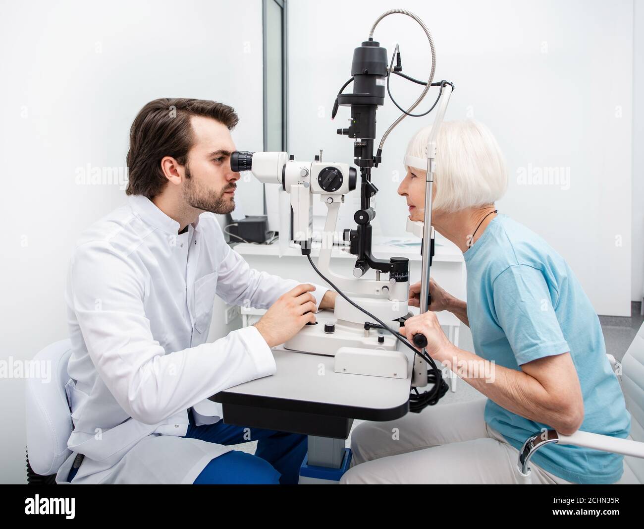 Optométriste effectuant des tests de vue pour une femme âgée dans une clinique moderne. Examen oculaire et diagnostic de la vision Banque D'Images