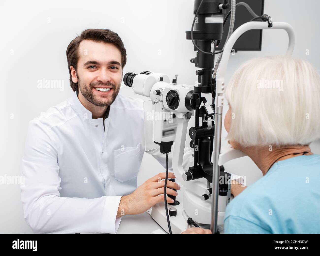 Portrait d'un ophtalmologiste positif au travail. Ophtalmologiste vérifiant la vue d'un patient âgé Banque D'Images