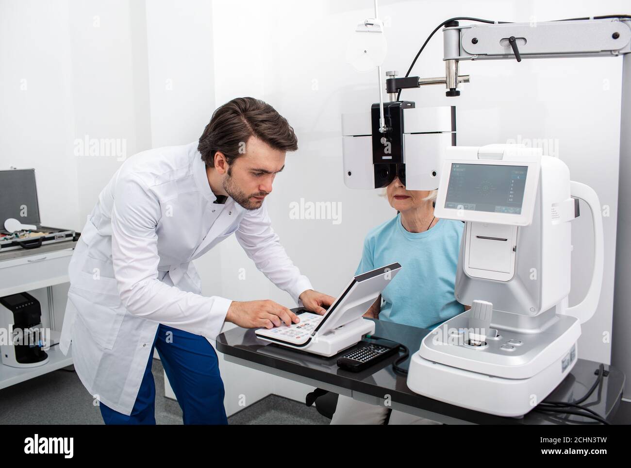 Optométriste expérimenté effectuant des tests sur site pour un patient utilisant un phoropter moderne dans une clinique médicale. Examen oculaire et diagnostic de la vision Banque D'Images