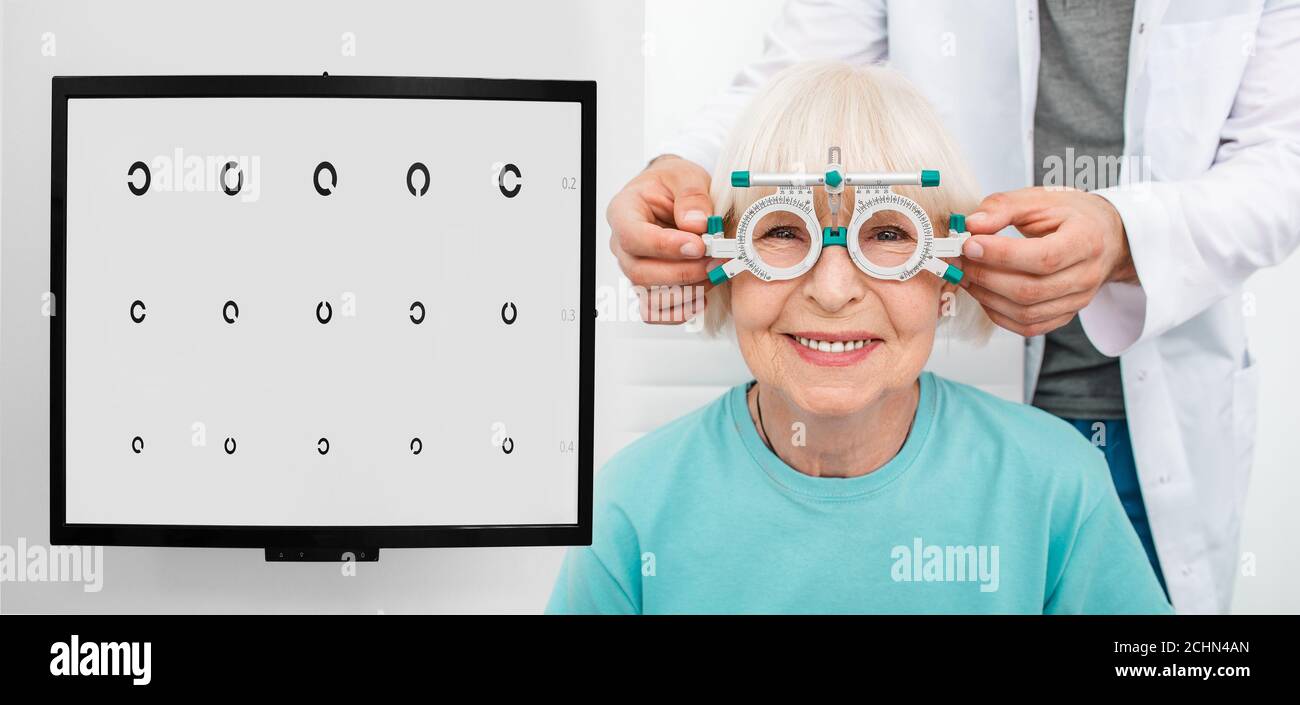 Femme âgée avec cadre d'essai optométriste sur ses yeux, en vérifiant la vision. Sélection de lunettes de dioptrie pour le choix de lunettes Banque D'Images