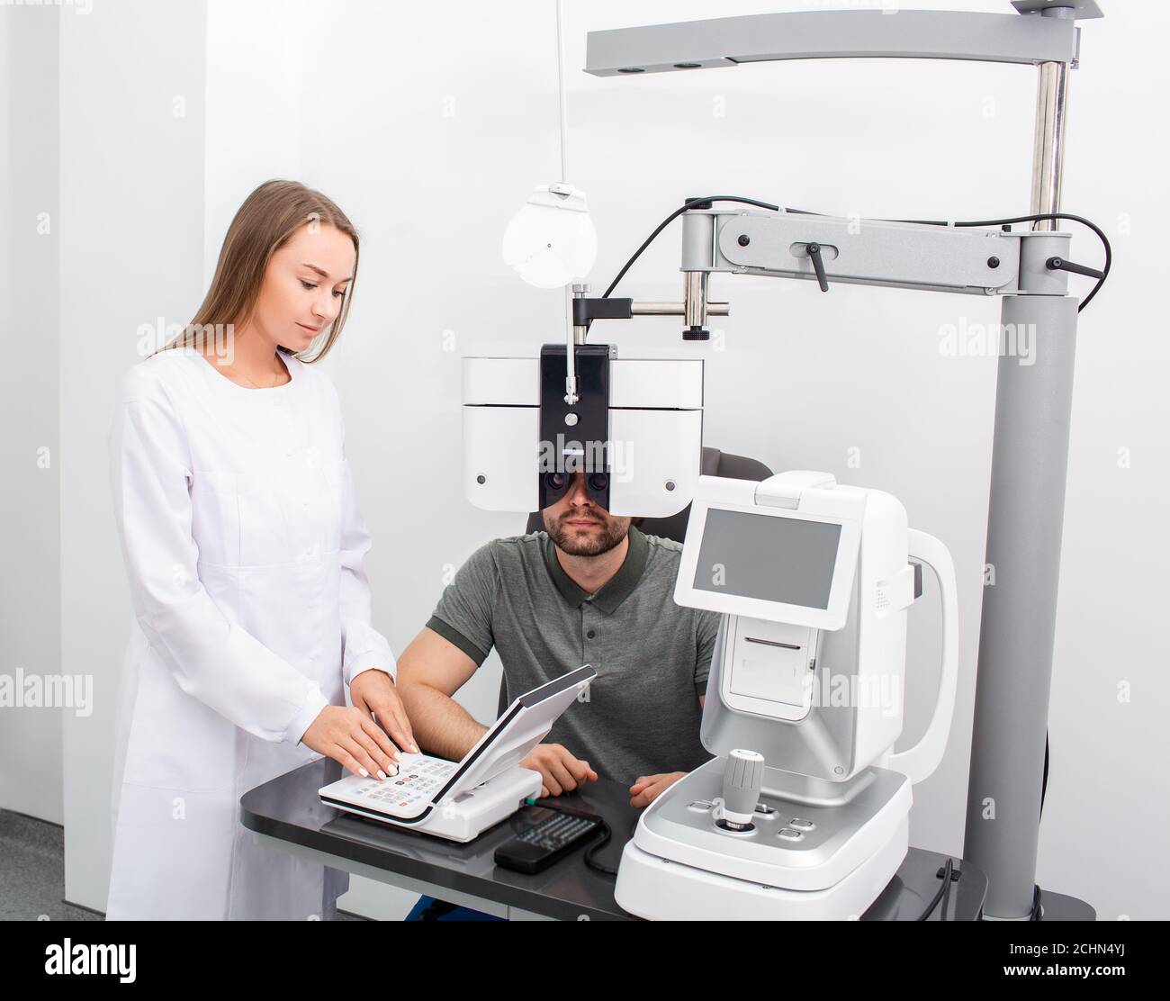 Femme ophtalmologiste effectuant des tests de vue pour un patient utilisant un phoropter moderne dans une clinique médicale. Examen des yeux et diagnostic de la vision adultes Banque D'Images