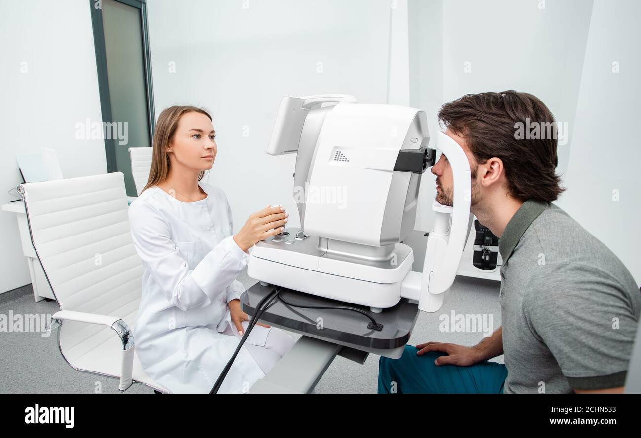 Optométriste à l'aide d'un auto-fractor, vérifier la vision du patient. Examen des yeux des adultes Banque D'Images