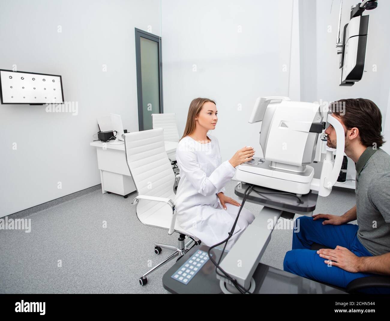L'ophtalmologiste pratiquant examine un patient d'homme avec un équipement ophtalmologique spécial dans une clinique moderne. Correction de la vision des adultes Banque D'Images
