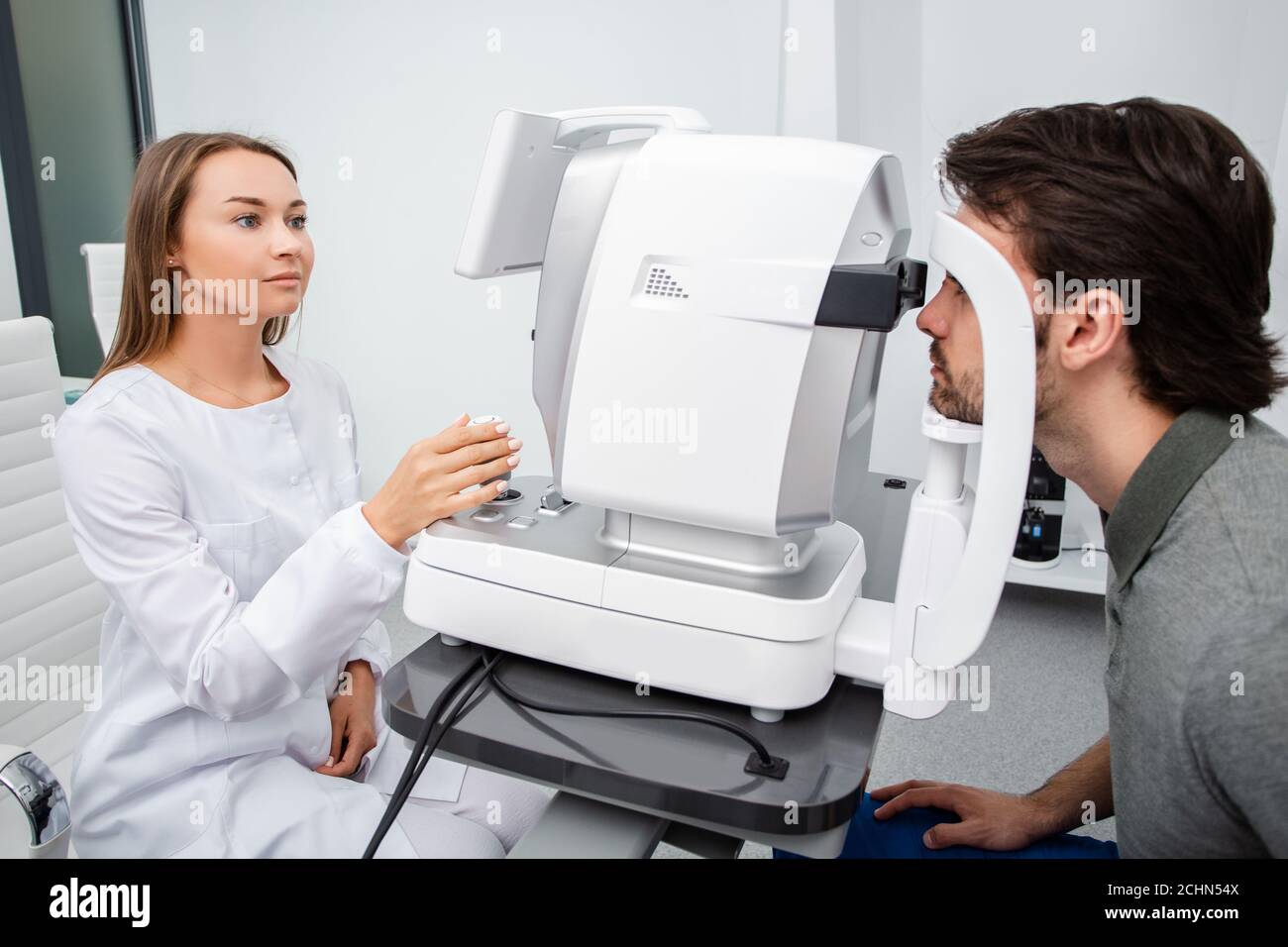 La femme médecin de l'œil fait un examen de vision diagnostique homme adulte. Concept de soins oculaires. Correction de la vision Banque D'Images