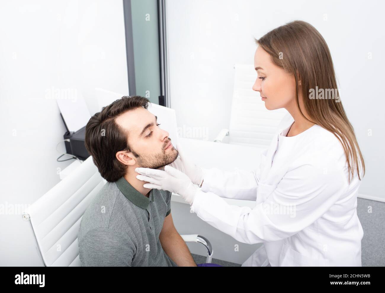 Expérience professionnelle endocrinologue vérifiant la glande thyroïde de l'homme beau patient par palpation. Un homme adulte a hypertrophié la glande thyroïde et le hormo Banque D'Images