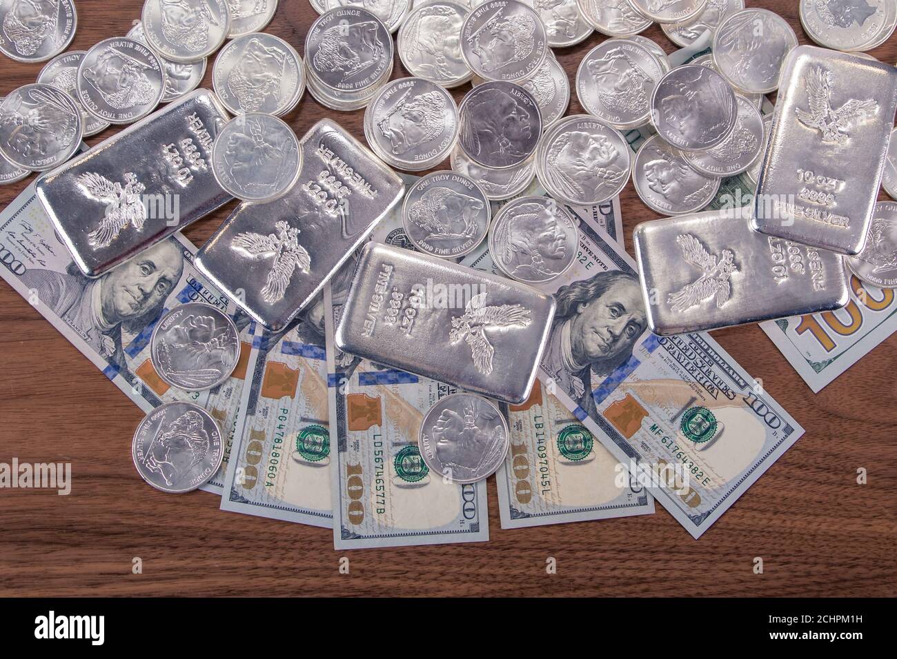Gros plan des barres d'argent et des pièces d'argent et 100 dollars factures sur table en bois Banque D'Images