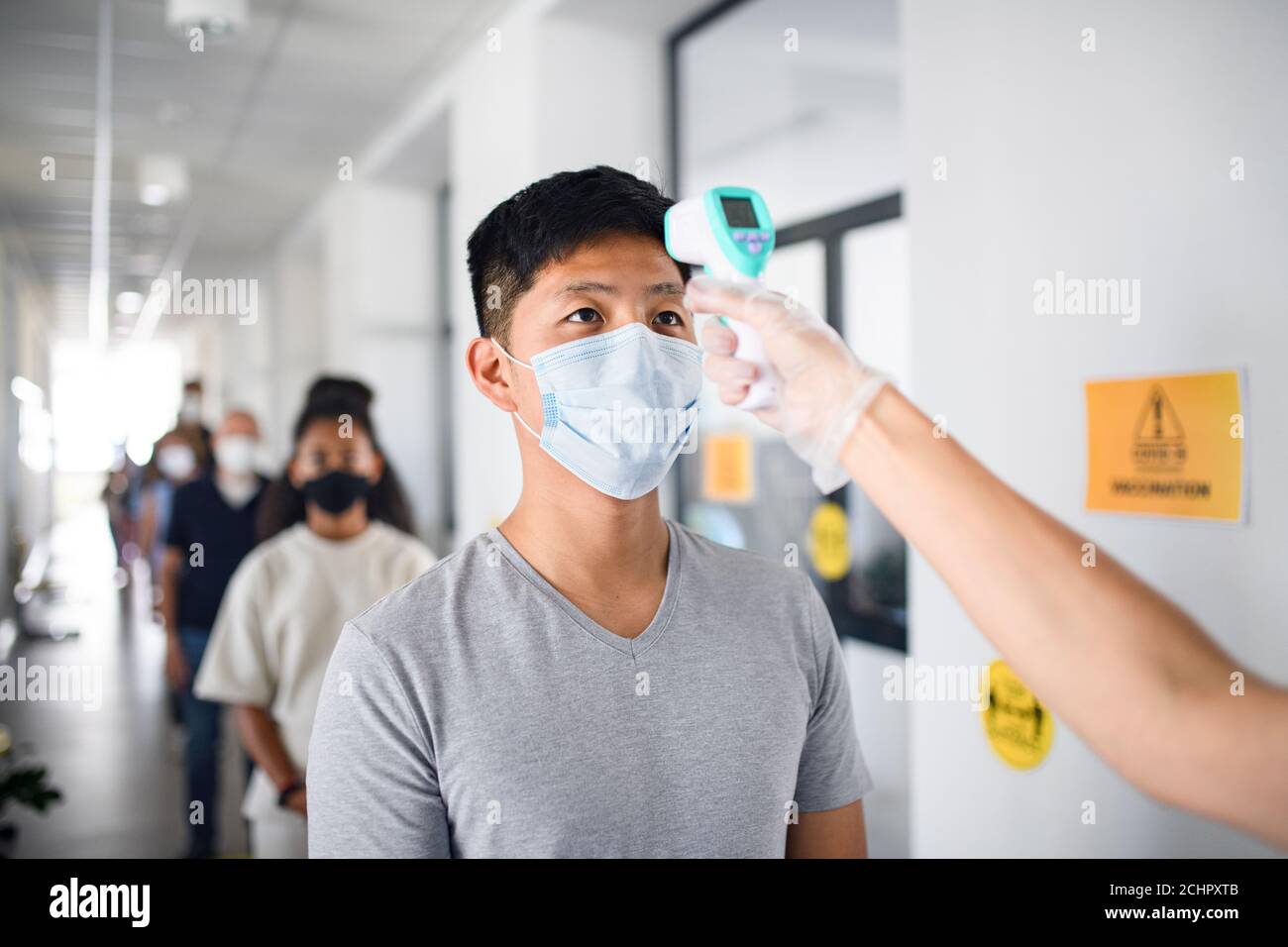Personnes avec masques faciaux, coronavirus, covid-19, mesure de la température et concept de vaccination. Banque D'Images