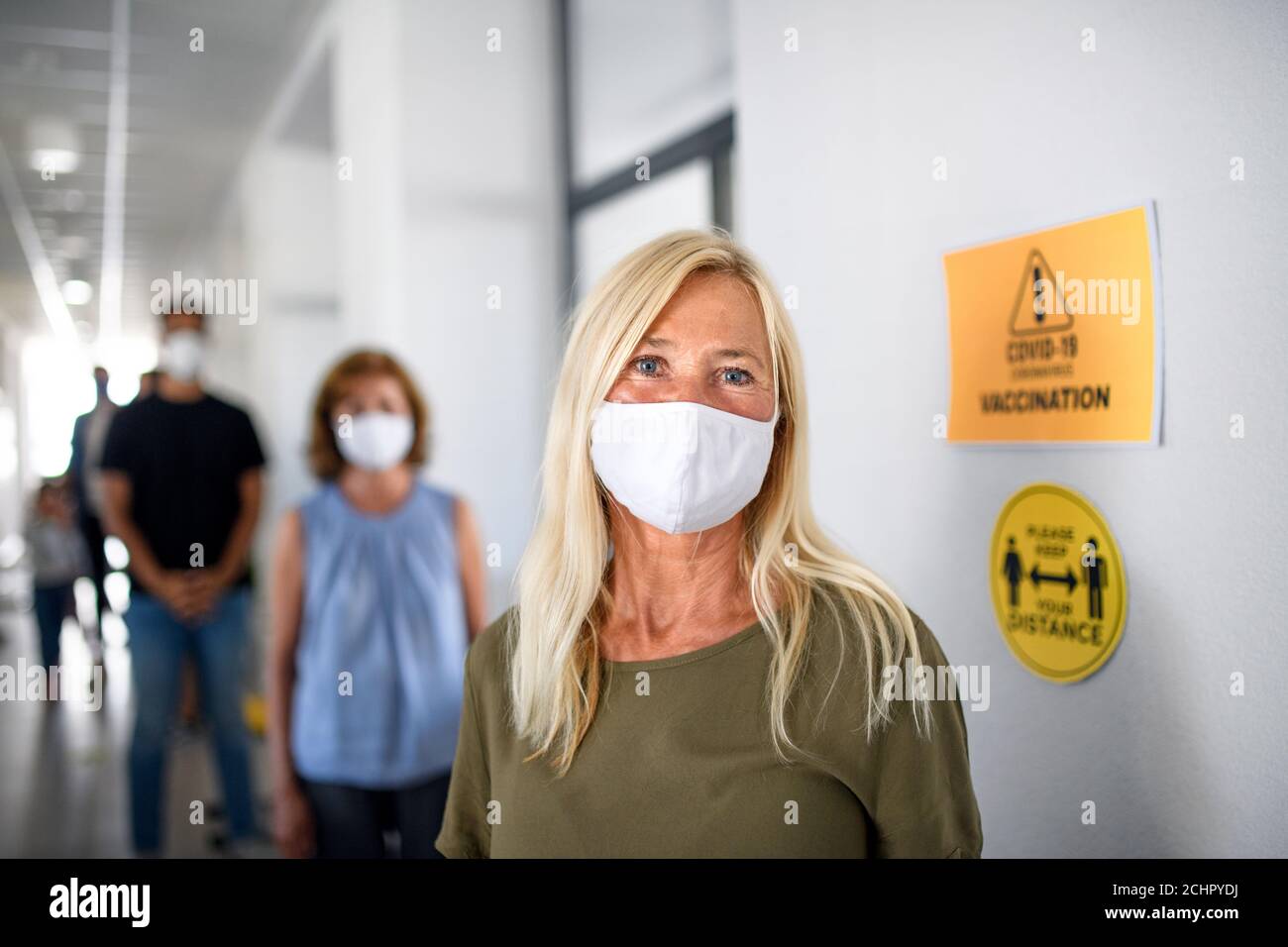 Portrait des personnes avec des masques de visage en attente, coronavirus, covid-19 et concept de vaccination. Banque D'Images