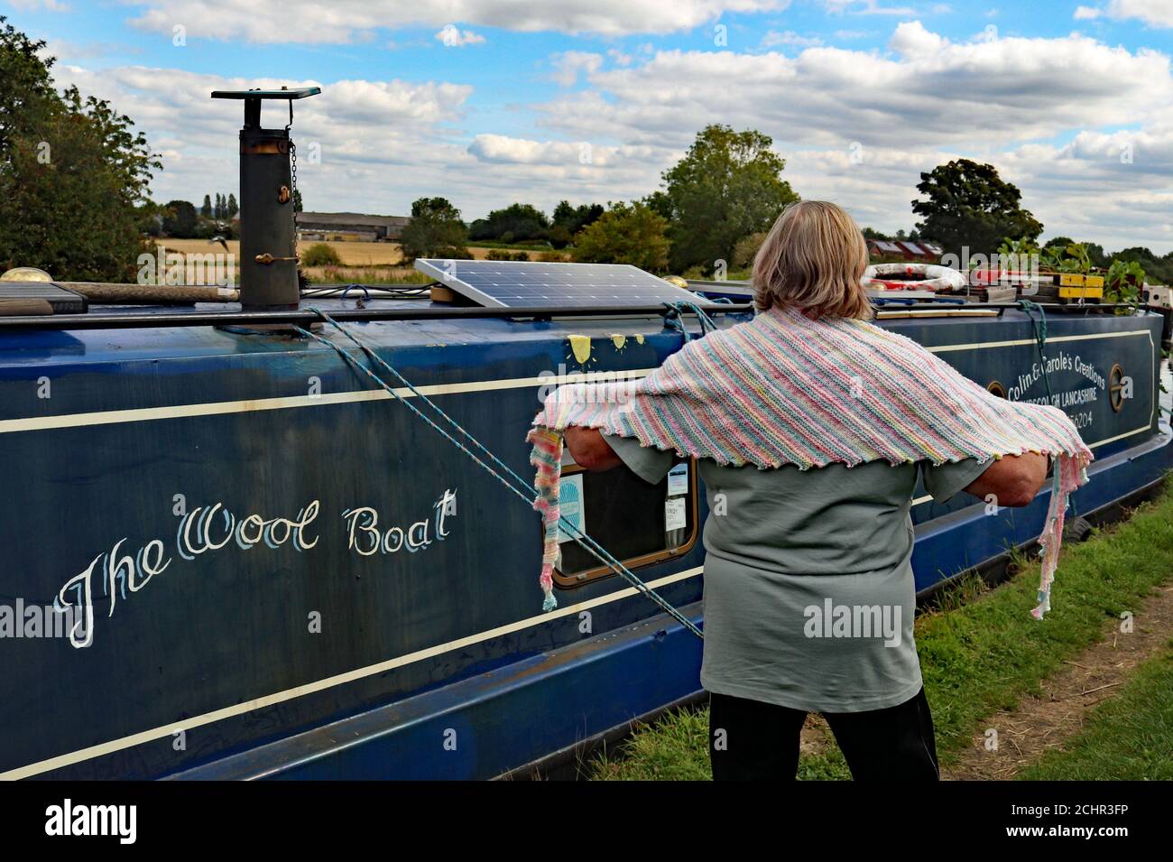 Un foulard de dragon pastel tricoté à la main à bord du bateau étroit "Emma Maye" dans le Lancashire par Carole Wareing qui montre le châle près du bateau. Banque D'Images