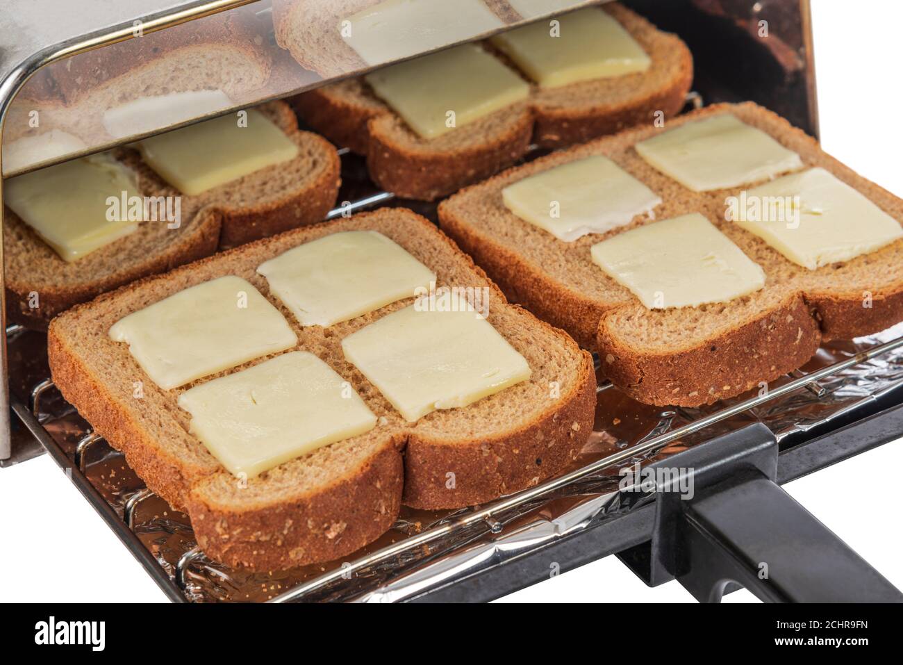 Dose horizontale de quatre morceaux de pain de blé beurré sur le point d'être poussé dans le grille-pain et grillé. Banque D'Images