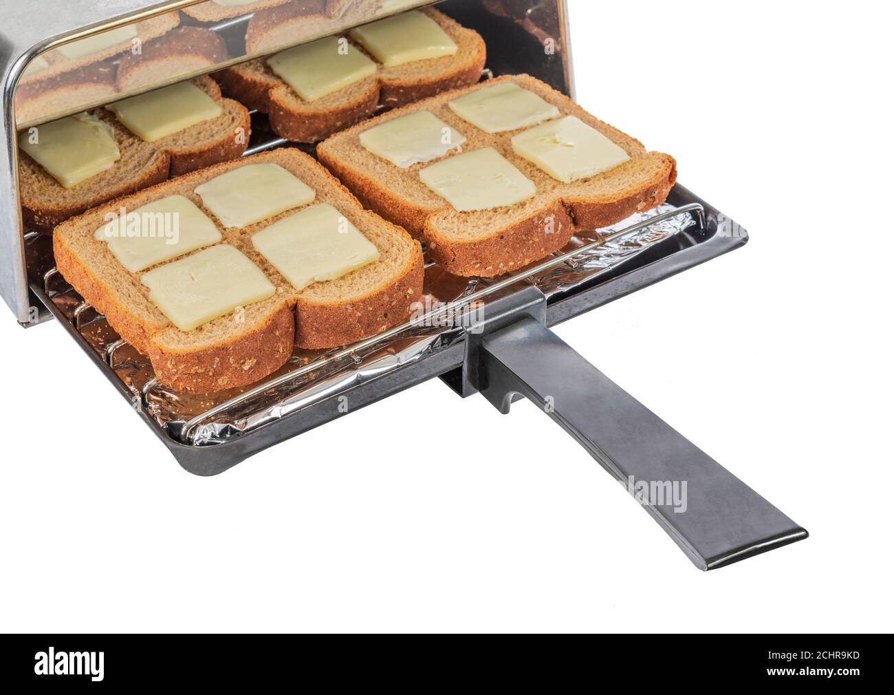 Dose horizontale de quatre morceaux de pain de blé beurré sur le point d'être poussé dans le grille-pain et grillé. Banque D'Images