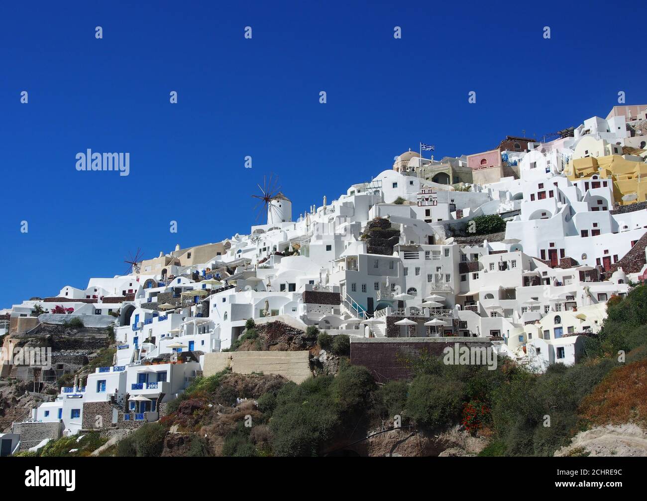 Maisons de grottes blanches sur les falaises de la caldeira contre un ciel bleu clair, Oia, Santorin Banque D'Images