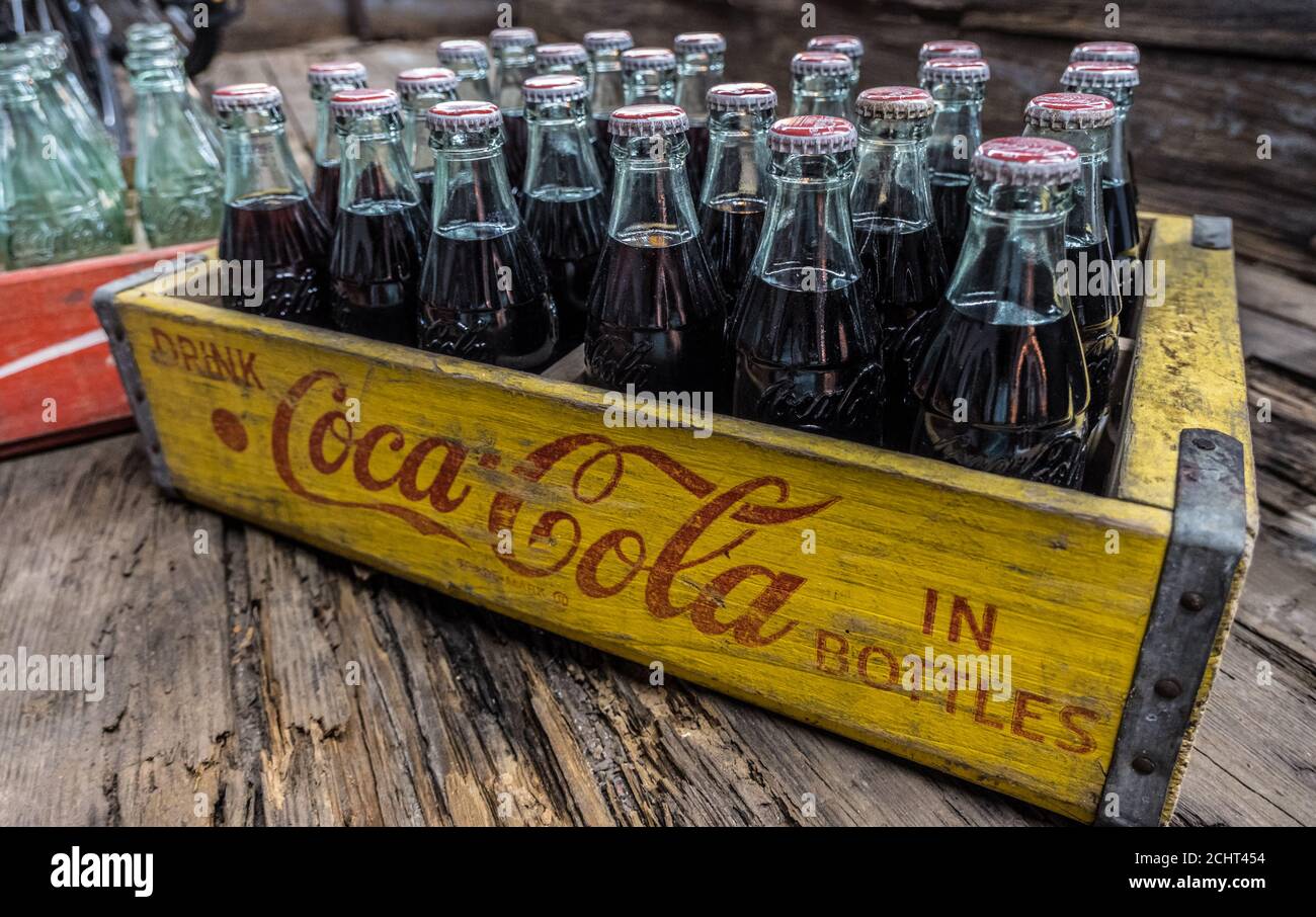 Bouteilles de verre Coca-Cola vintage avec du cola encore dans les bouteilles dans une caisse de livraison en bois, sur un plancher en bois gros plan Banque D'Images