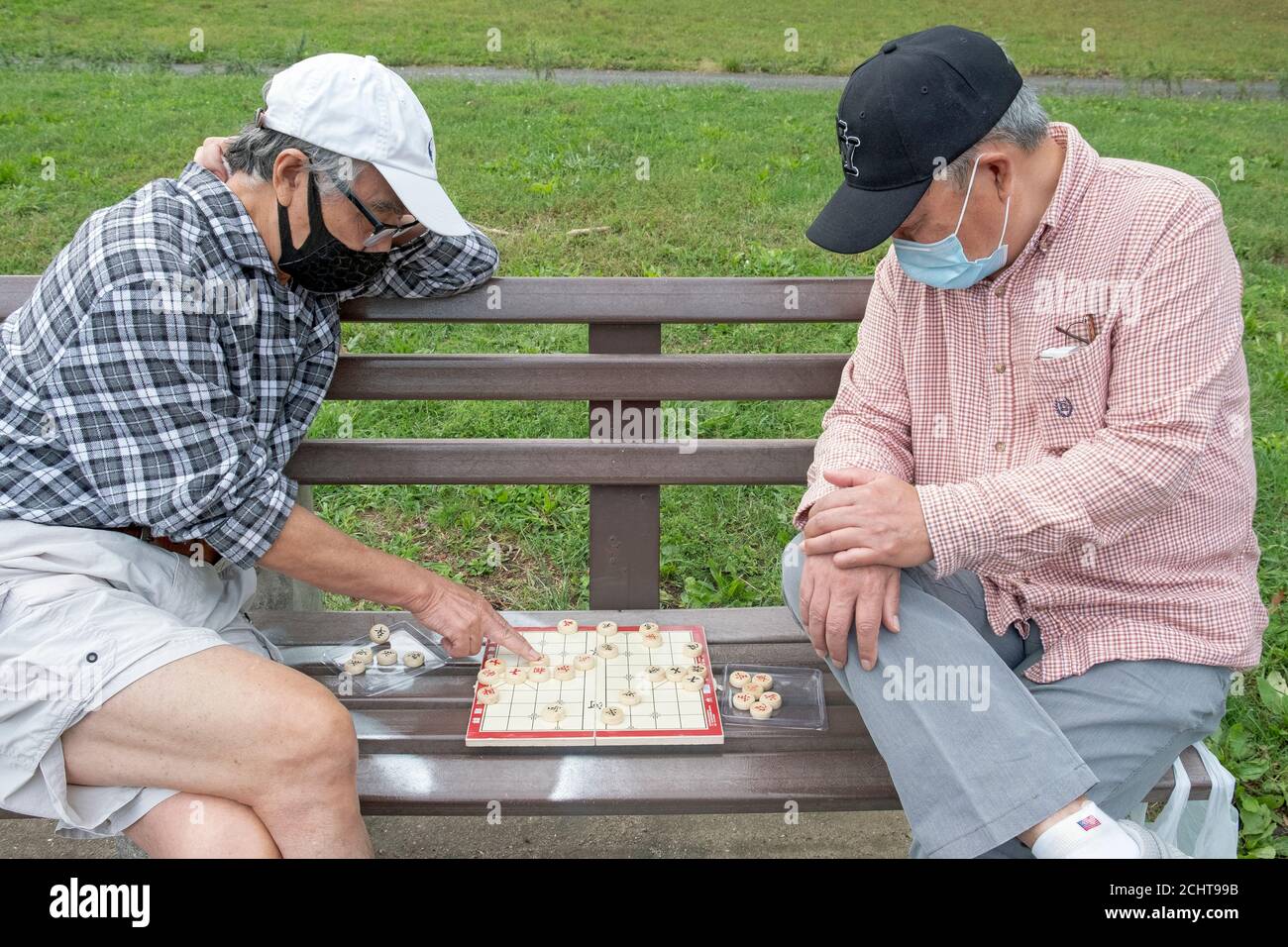 Deux hommes chinois américains plus âgés jouent Xiangpi, parfois appelés échecs chinois. Dans un parc à Flushing, Queens, New York. Banque D'Images