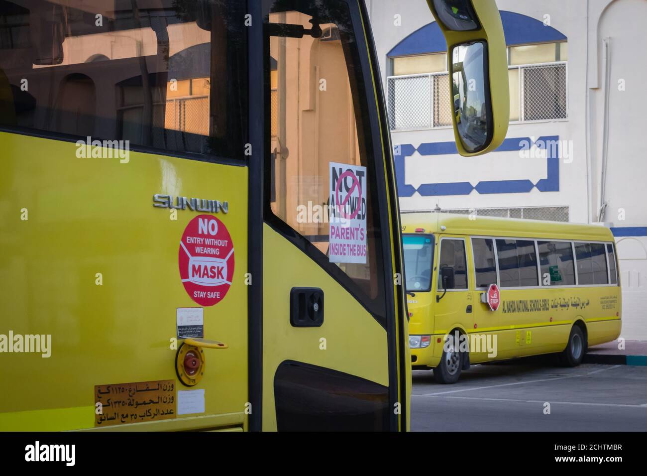 Autobus scolaire jaune à Abu Dhabi, Émirats arabes Unis, Dubaï, Émirats, Golfe, Moyen-Orient. Des signes et symboles de sensibilisation ont été écrits en langue arabe à Banque D'Images