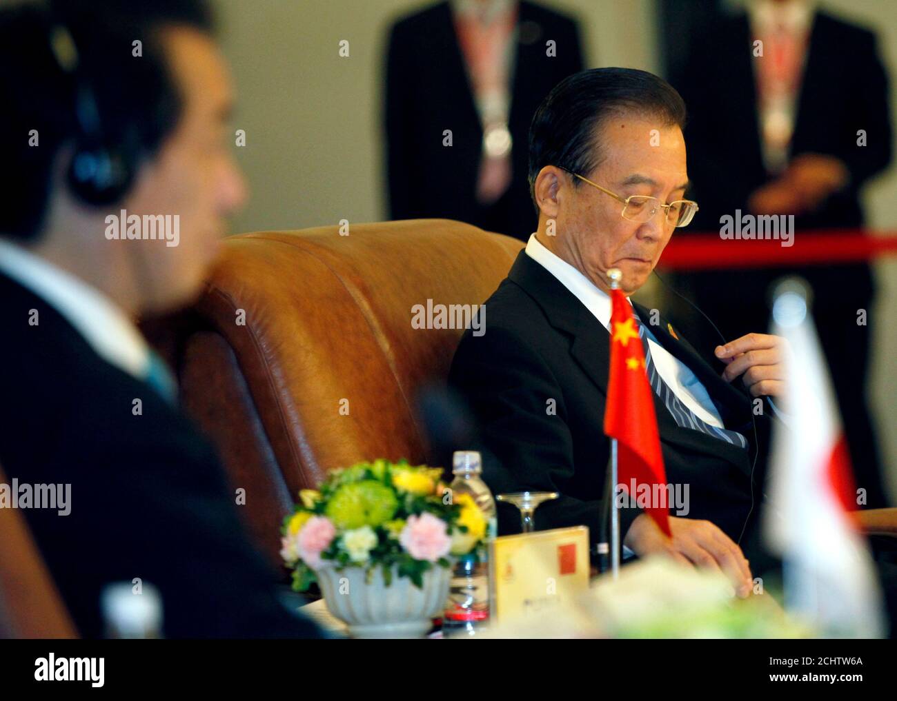 Le Premier ministre chinois Wen Jiabao (R) ajuste ses écouteurs alors que le Premier ministre japonais Naoto Kan se trouve à côté de lui lors du 13ème Sommet ASEAN plus trois, en marge du 17ème Sommet de l'ANASE à Hanoï le 29 octobre 2010. Les liens entre la Chine et le Japon se sont détériorés le mois dernier après la détention d'un capitaine de bateau de pêche chinois par la garde côtière japonaise après la collision de leurs bateaux près d'îles contestées en mer de Chine orientale. REUTERS/Damir Sagolj (VIETNAM - Tags: POLITIQUE) Banque D'Images