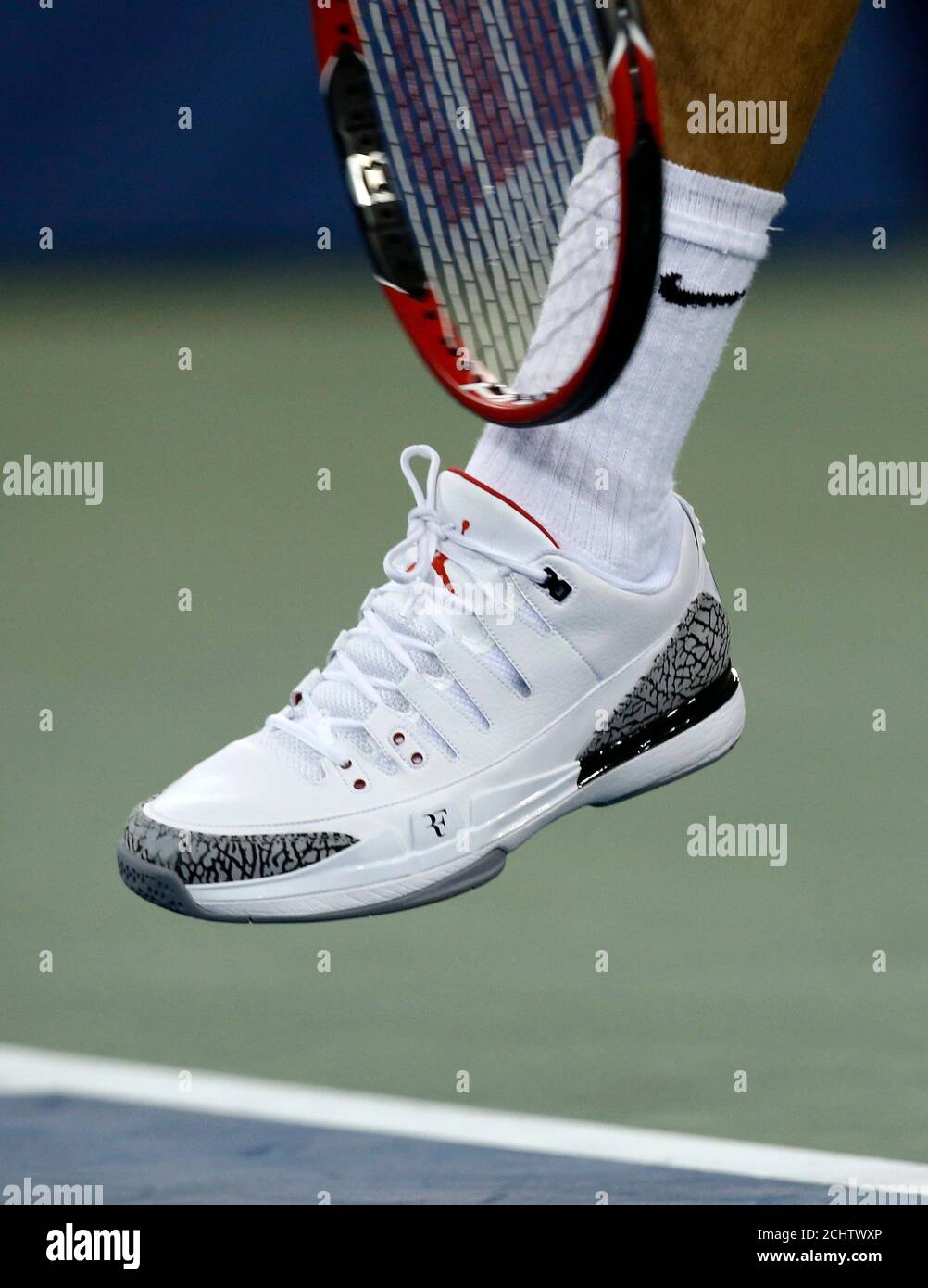 Roger Federer de Suisse sert tout en portant une nouvelle chaussure, la  Nike Zoom Vapor 9 Tour AJ3 il a participé à la conception avec le grand  Michael Jordan de basket-ball, lors