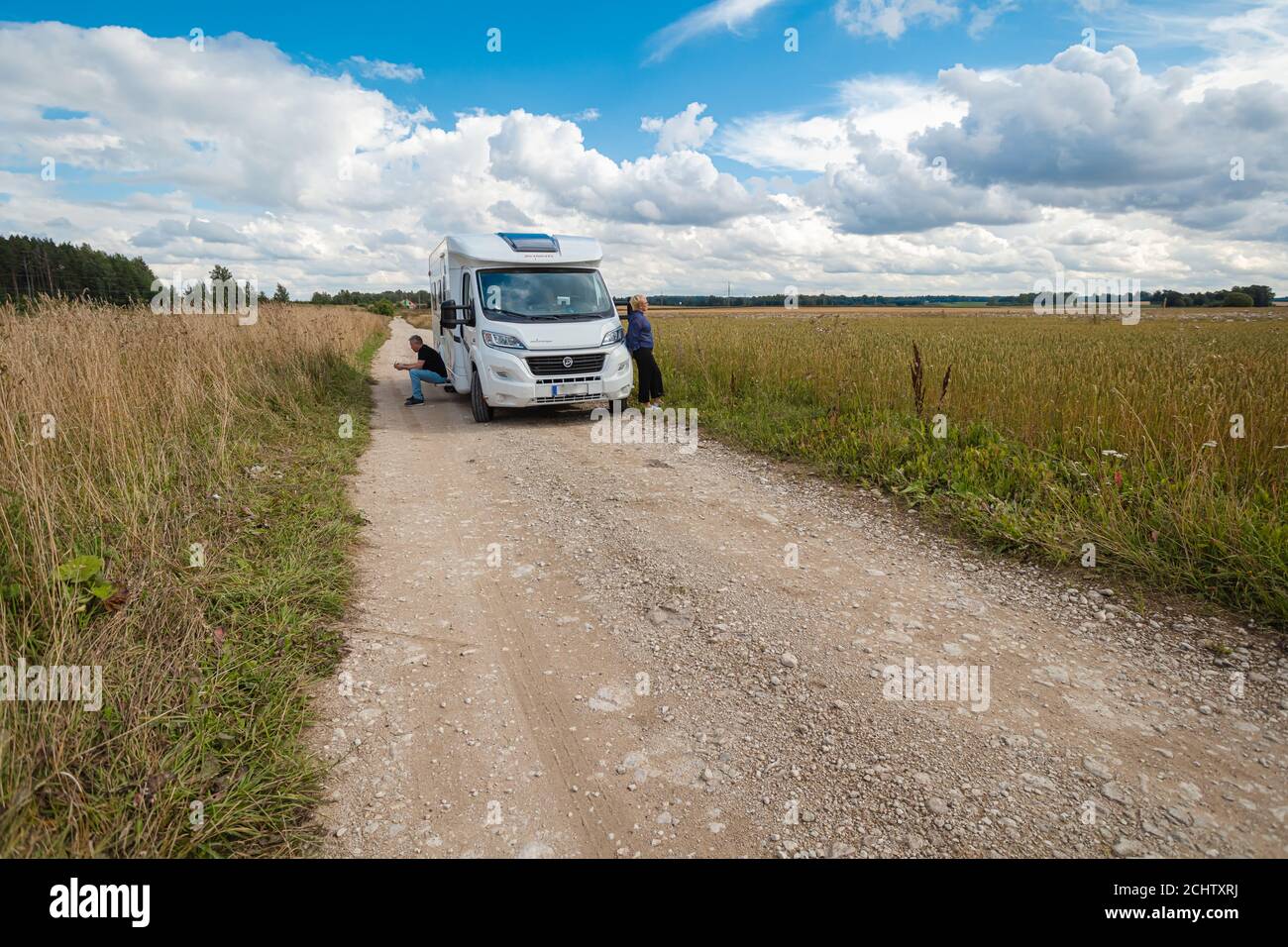 Paysage d'un champ et d'une voiture sur une route de campagne, maison de voiture, jour d'été, août, homme et femme Voyage. Photo de haute qualité Banque D'Images