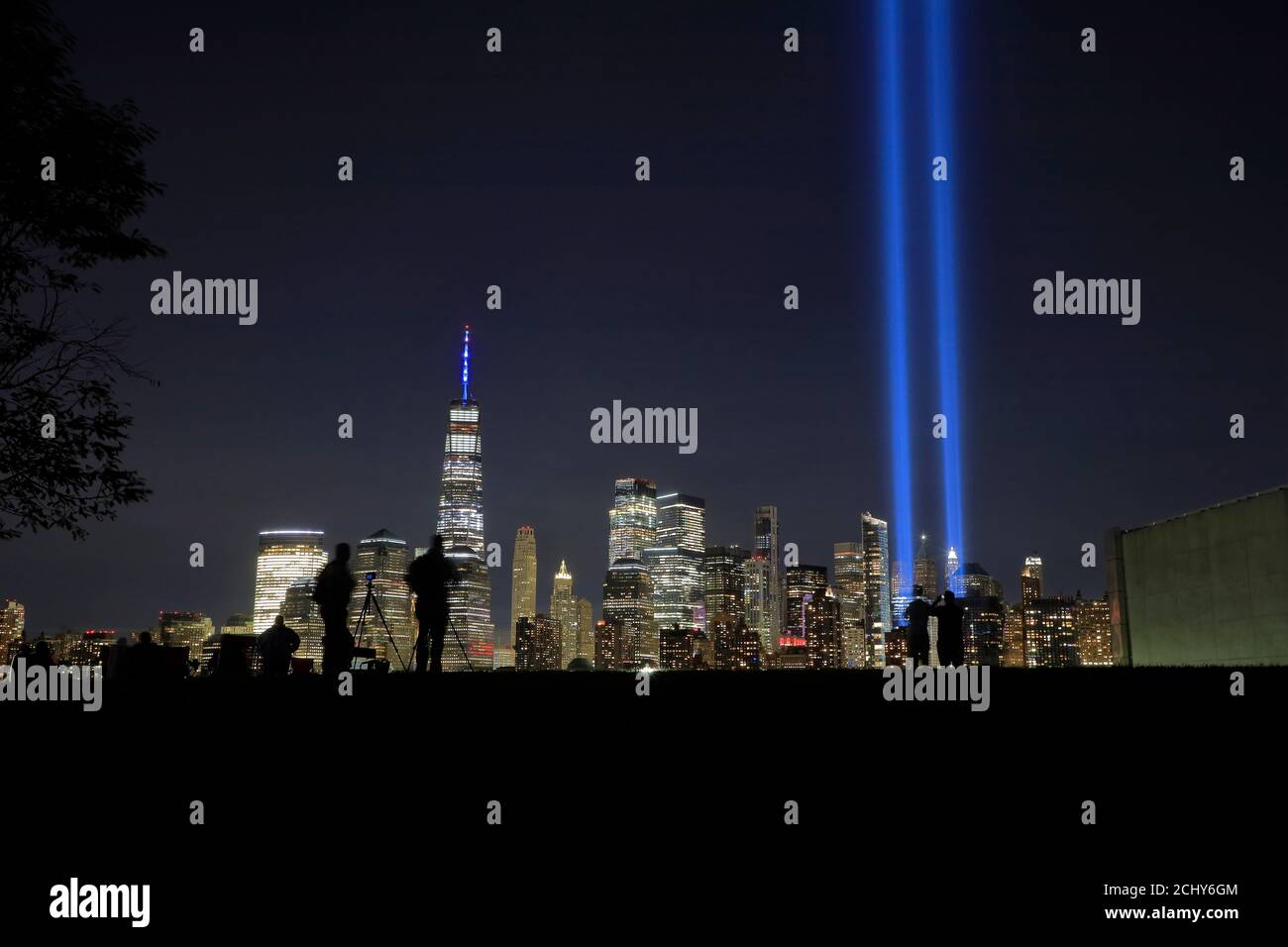 Les faisceaux lumineux annuels « hommage à la lumière » projettent de nuit Sky of Lower Manhattan à la mémoire du 11 septembre attaques terroristes victimes Avec des personnes qui la consultent dans Liberty State Park en premier plan.Nouveau Jersey. États-Unis Banque D'Images