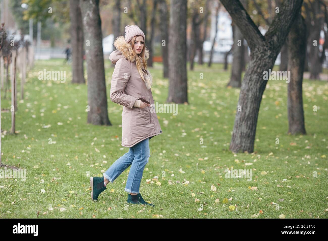 Jolie jeune femme marche dans le parc en automne Banque D'Images