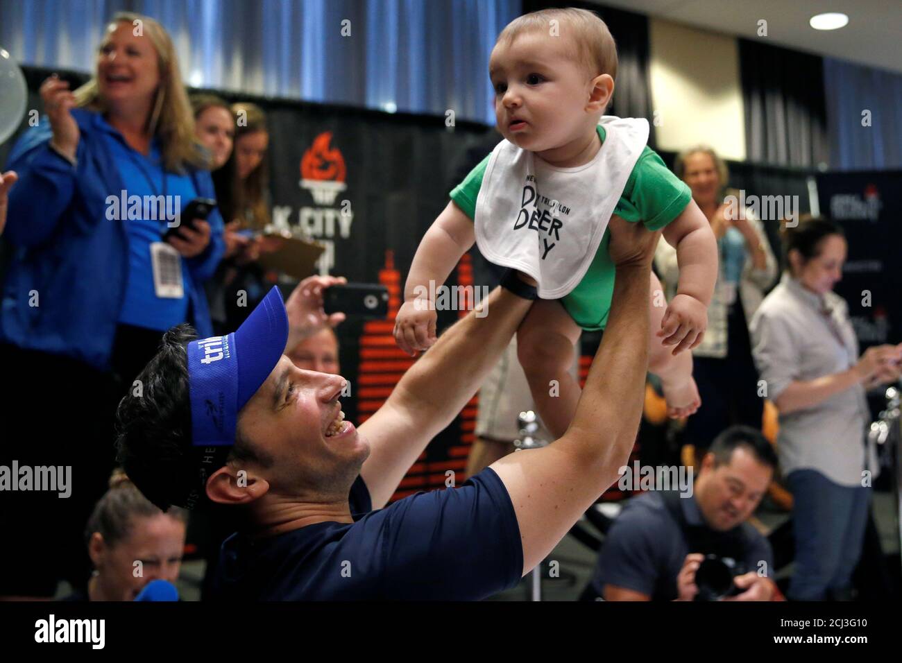 Un Pere Tient Son Bebe Apres Avoir Pris Part A Une Course De Chaleur Dans Le Diaper Derby 17 Un Evenement De Promotion Devant Le Triathlon De La Ville De New York
