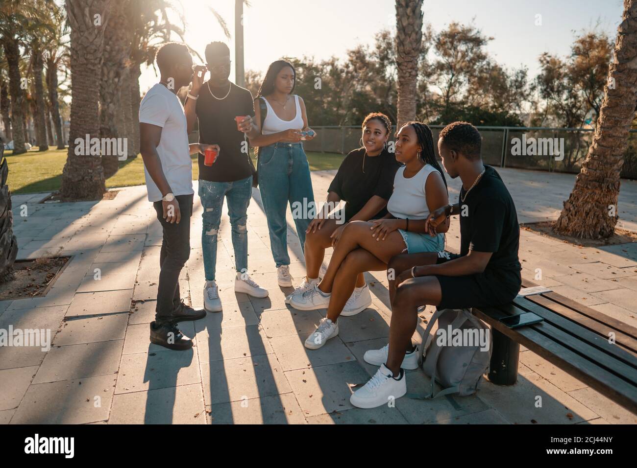 Groupe de jeunes amis noirs africains modernes heureux de s'asseoir ensemble Banque D'Images