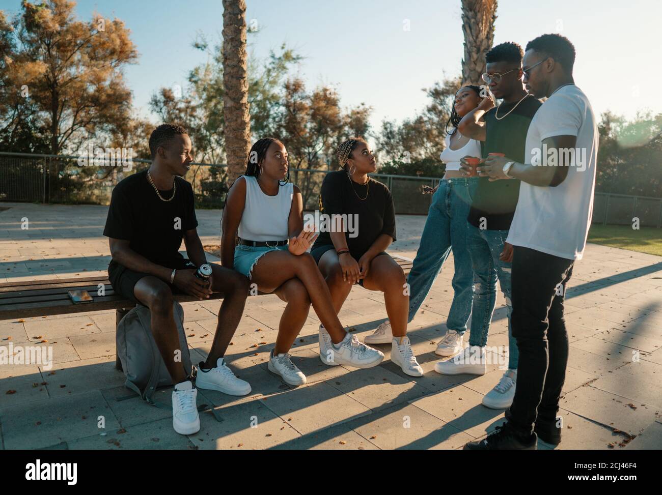 Groupe de jeunes amis noirs africains modernes heureux de s'asseoir ensemble Banque D'Images