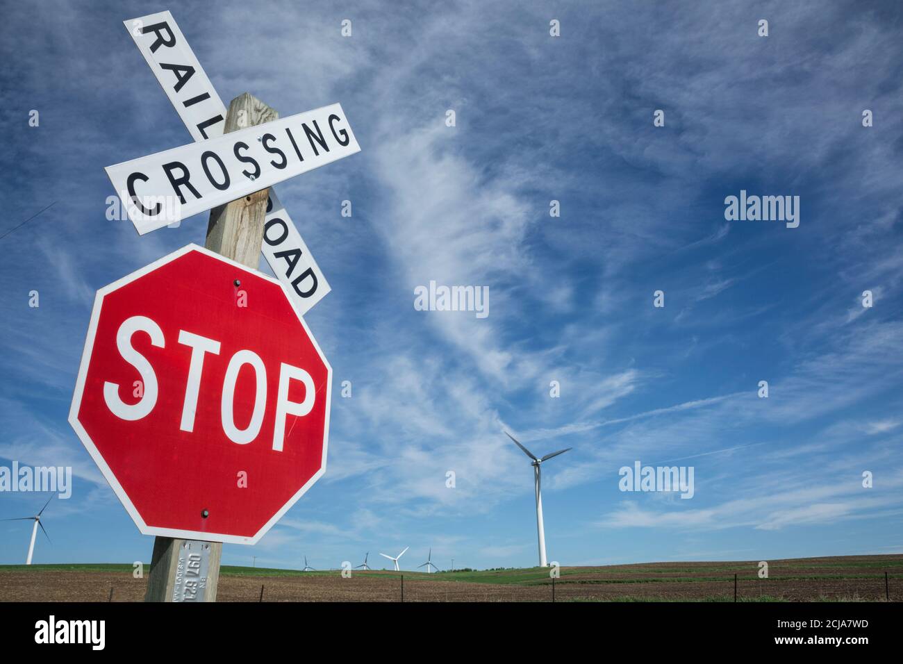 Chemin de fer croisement et panneau Stop contre le ciel bleu, les éoliennes à distance, Hollande, Minnesota, USA. Banque D'Images